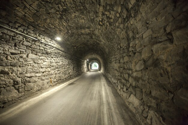 Great shot of the entrance of an old stone tunnel from the other end of an old stone tunnel