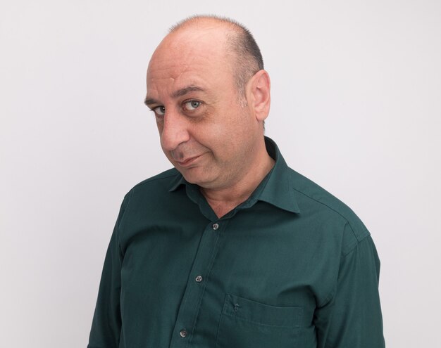 Greedy  middle-aged man wearing green t-shirt isolated on white wall