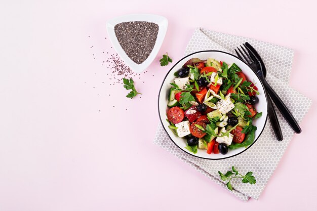 Greek salad  with cucumber, tomato, sweet pepper, lettuce, green onion, feta cheese and olives with olive oil. Healthy food. Top view