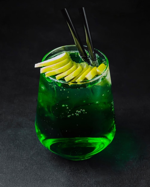 Зеленый алкогольный коктейль с нарезанным лимоном на верхней стороне