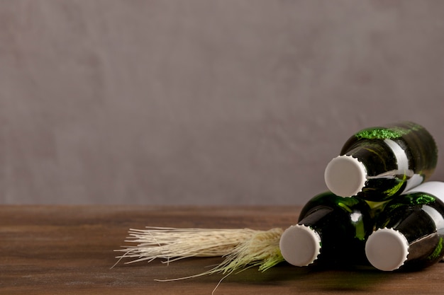 Green alcoholic bottles in white label on wooden table