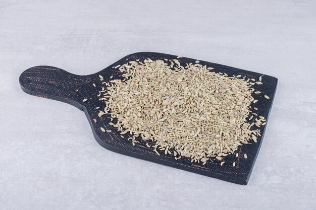 green anise seeds on a wooden board on concrete surface
