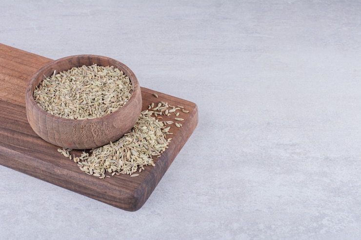 Free Photo green anise seeds on a wooden board on concrete surface