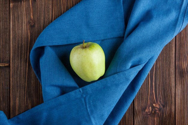 파란 피복 및 나무 배경에 녹색 사과. 평면도.