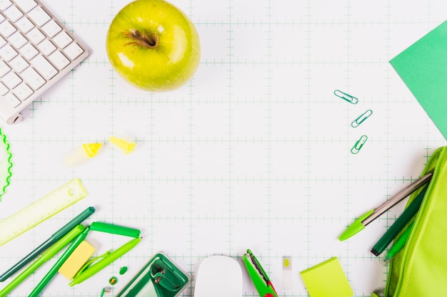 Foto gratuita mela verde e kit di articoli di cancelleria