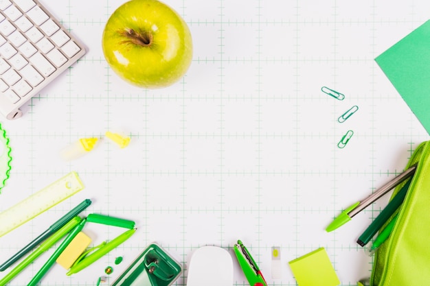 Green apple and kit of stationery