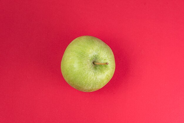 Green apple on red