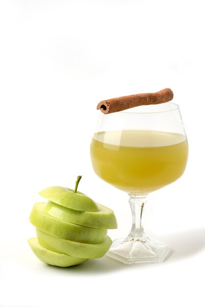 Green apple whole and sliced on white with a glass of juice