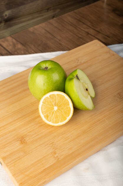 木の板に新鮮なレモンと青リンゴ。上面図