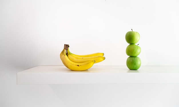 Зеленые яблоки и бананы на белом фоне крупным планом