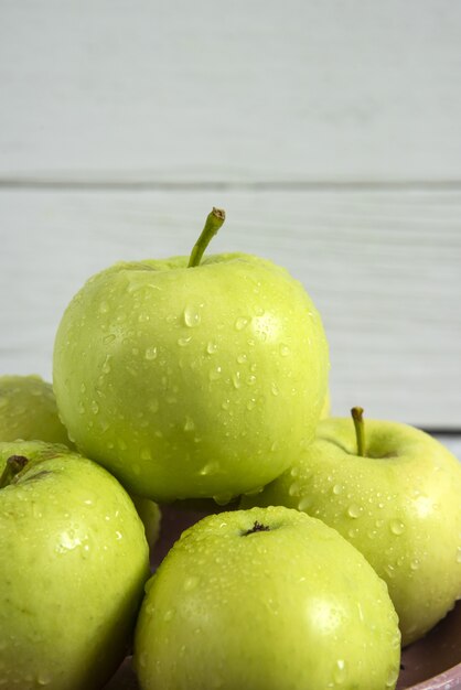 Green apples in a ceramic saucer