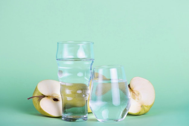 Green apples and different sized glasses arrangement 