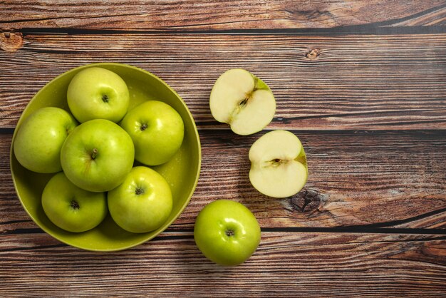 Green apples in a green ceramic bowl, top view