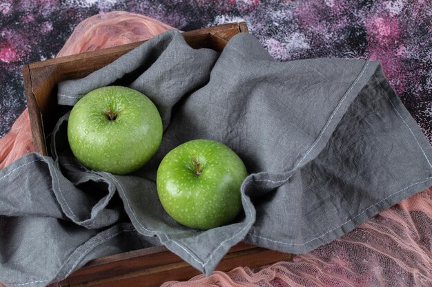 Green apples on grey kitchen towel.