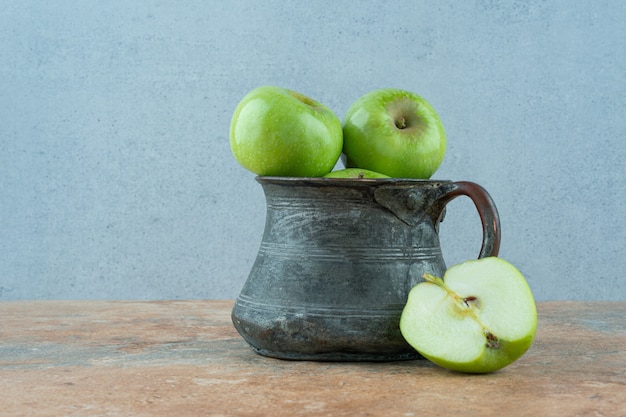 Green apples in a iron dish.