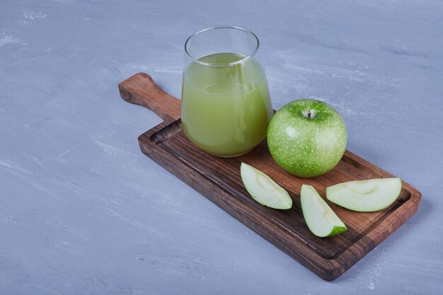 Green apples with a glass of juice.