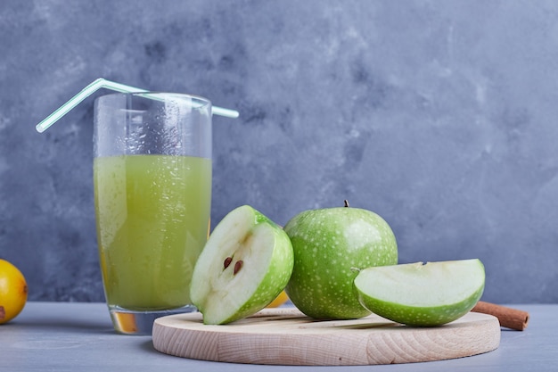 Free photo green apples with a glass of juice.