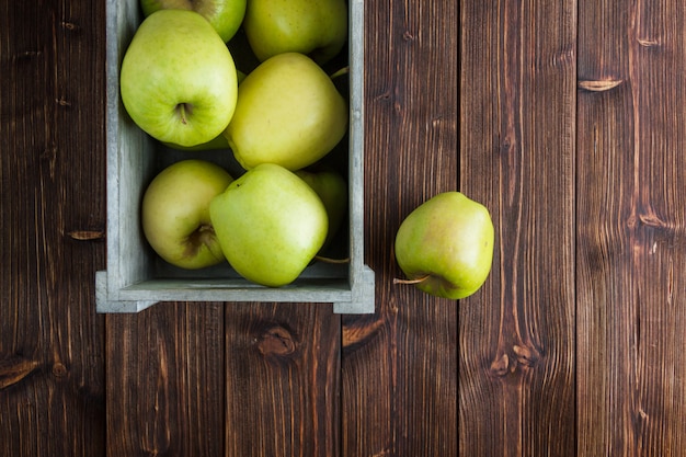 木製の背景に木製の箱で緑のリンゴ。フラット横たわっていた。テキスト用の空き容量