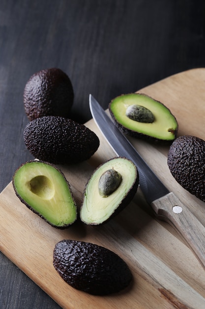 Green avocados on cutting board