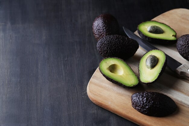 Green avocados on cutting board