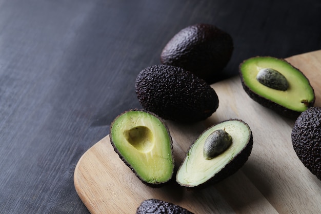 Green avocados on cutting board