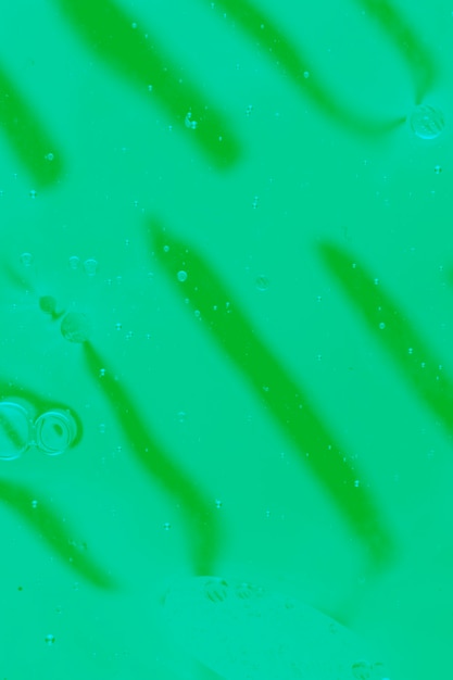 Green background with oil bubbles on water surface