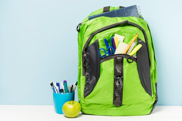 Green backpack with school accessories