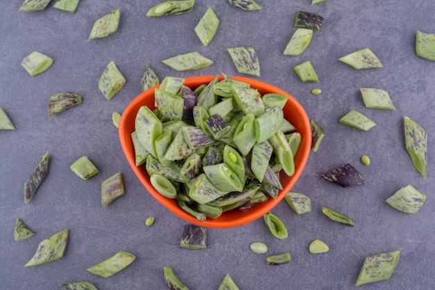 Green beans isolated in a wooden tray on blue surface