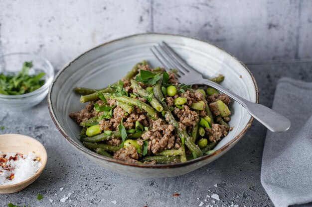 Зеленая фасоль с мясным фаршем в миске