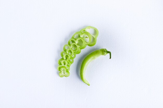 Green bell pepper slices on a white table.