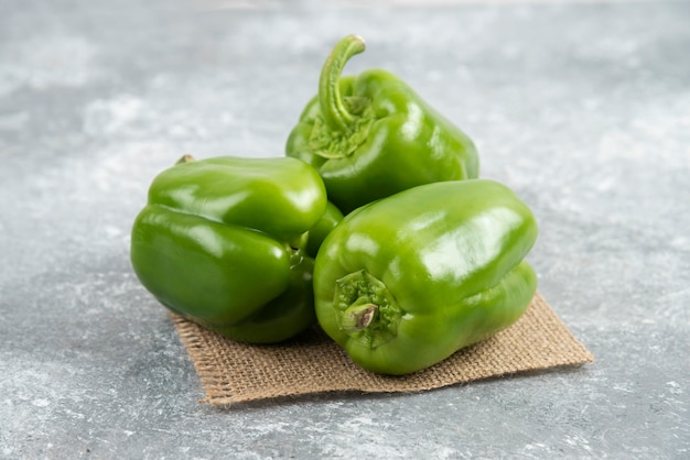 Green bell peppers on a piece of burlap.