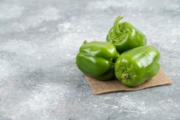 Green bell peppers on a piece of burlap.