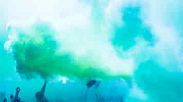 Free photo green and blue holi color powder over the crowd