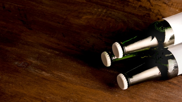 Free photo green bottles of beer on wooden table