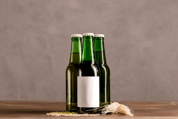 Green bottles in white label on wooden table