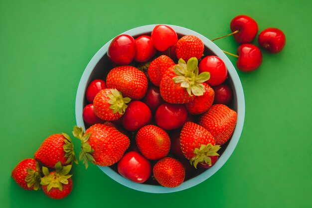 Green bowl with red fruits