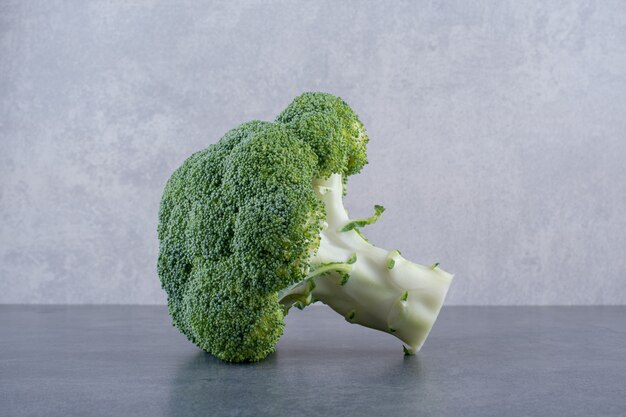 Green broccoli isolated on concrete background.