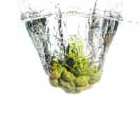 Free photo green broccoli splashes into clean water over the white backdrop