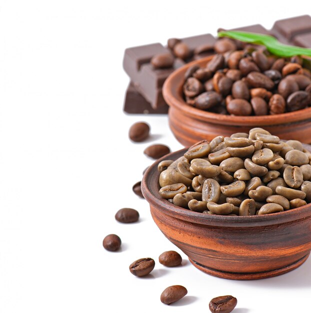 Green and brown coffee beans in bowls