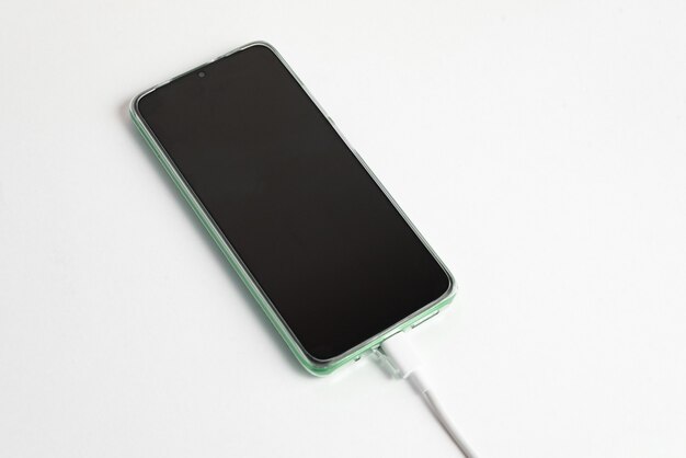 USBケーブルタイプCに接続された緑色の携帯電話-充電