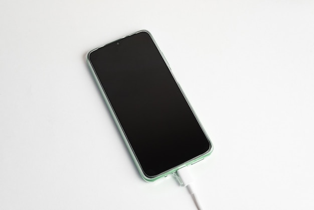 USBケーブルタイプCに接続された緑色の携帯電話-充電
