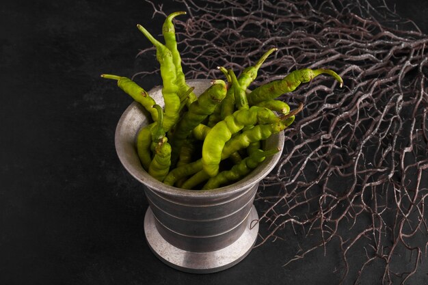 Green chili peppers in a metallic pot. 