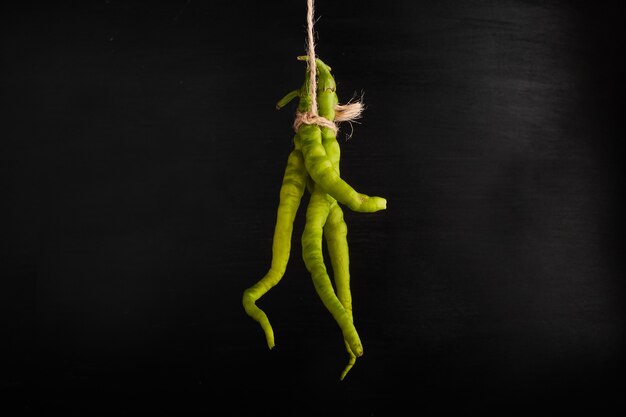 Green chilies hanged from a thread. 