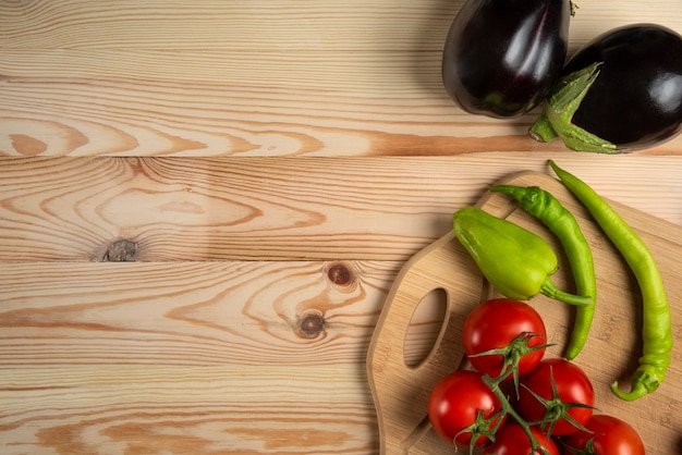 Green chilies and tomatoes on the wooden table