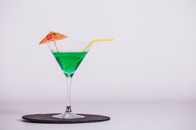 Free photo green cocktail with umbrella and straw