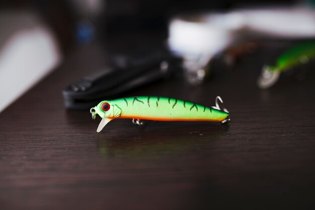 Green colored fishing hook on wooden desk