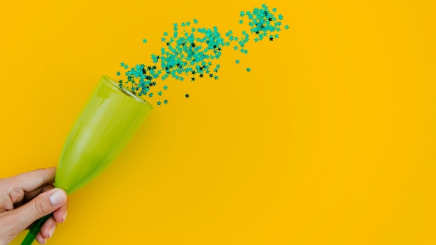 Free photo green confetti on yellow background