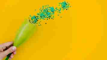 Free photo green confetti on yellow background