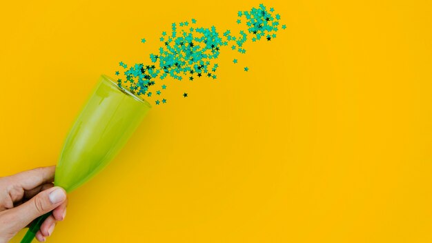 Green confetti on yellow background