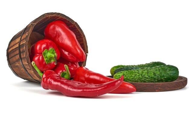 Green cucumber on a wooden platter with chilies in the bucket.